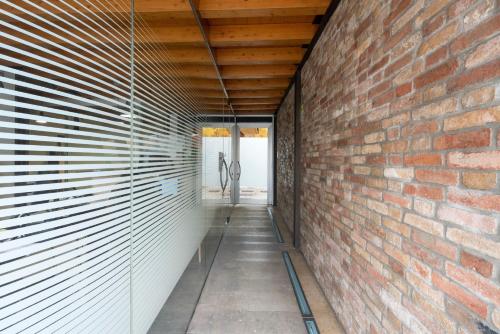 a brick wall divides the hallway from the house at [Elegant Suite Piave]Venezia Outlet in Noventa di Piave