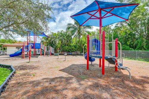 a playground with blue and red playground equipment at Sunny Florida Escape with Patio, Grill and Fire Pit! in Naples