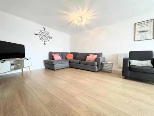 a living room with a couch and a television at Newquay Fistral Beach View with pool in Newquay