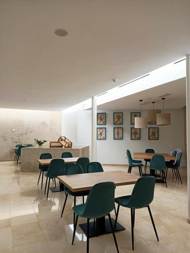 a dining room with tables and green chairs at HOTEL BOUTIQUE VILAVELLA in O Grove
