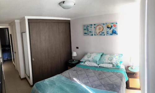 a small bedroom with a bed in a room at Acogedor departamento a pasos de la playa in Coquimbo