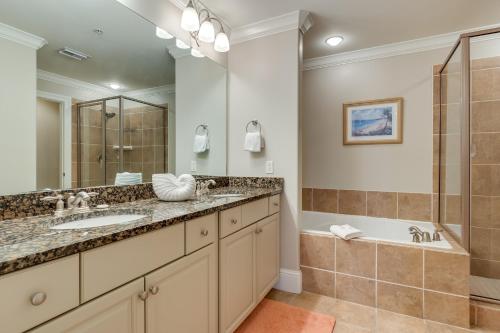 a bathroom with two sinks and a shower and a tub at Dauphin Island Condo in Holiday Isle with Balcony! in Dauphin Island