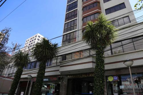 dos palmeras delante de un edificio en Hermosa Habitación en Av Arce frente a Multicine en La Paz