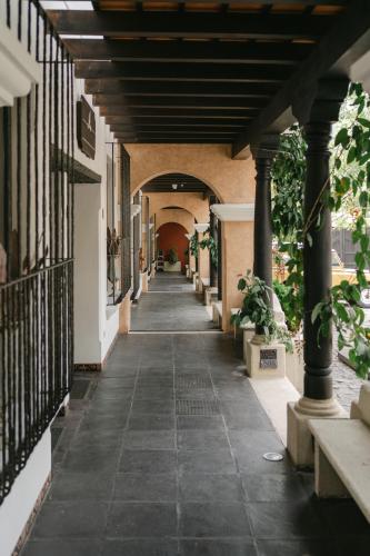 an arcade with a hallway with pillars and plants at Boutique Villa in Antigua in Antigua Guatemala