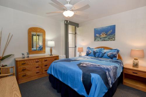 a bedroom with a blue bed and a ceiling fan at Maalaea Banyans 113 in Maalaea
