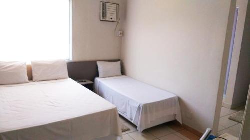 a small room with two beds and a window at Santos Hotel in Santos