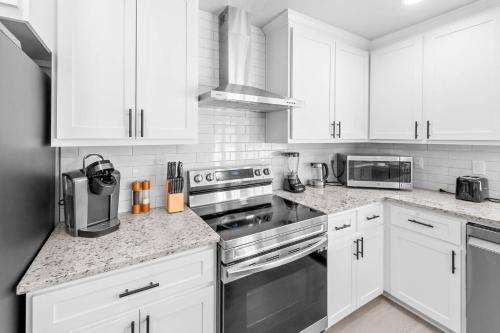 a kitchen with white cabinets and stainless steel appliances at Colony Retreat in The Colony