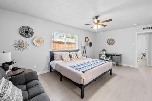 a bedroom with a bed and a couch and a ceiling fan at Colony Retreat in The Colony