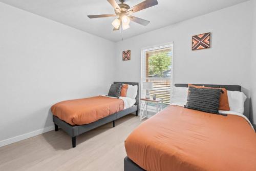 a bedroom with two beds and a ceiling fan at Colony Retreat in The Colony