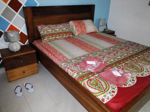 uma cama com um edredão vermelho e almofadas em Villa magnifique avec piscine em Somone