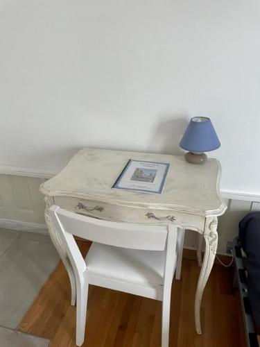 une petite table blanche avec une lampe bleue sur elle dans l'établissement Studio tout confort bien situé, à Orléans