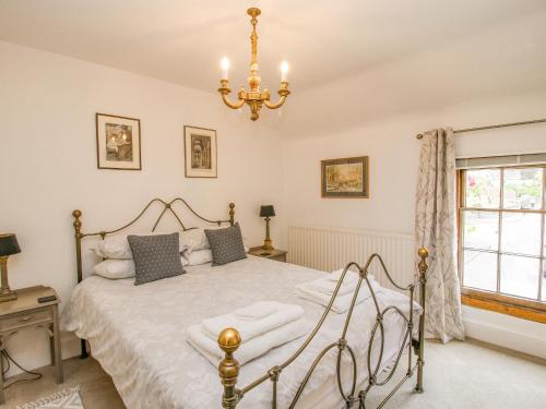 Schlafzimmer mit einem Bett und einem Kronleuchter in der Unterkunft Queens Cottage in Much Wenlock