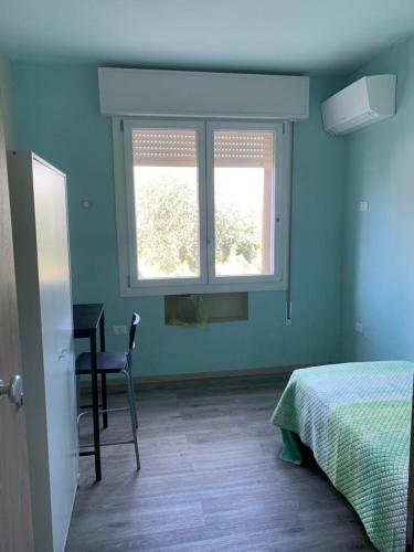 1 dormitorio con 1 cama, escritorio y 2 ventanas en VeniceMaskPadova, en Padua