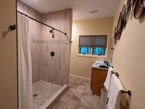 baño con ducha y puerta de cristal en Poplar Treehouse - Rustic Luxury en Marshall