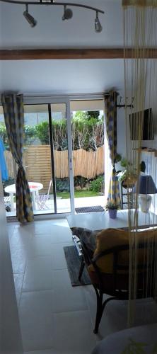 - un salon avec une table et une vue sur un patio dans l'établissement studio climatisé, indépendant avec baie vitrée et jolie terrasse, à Coulommiers