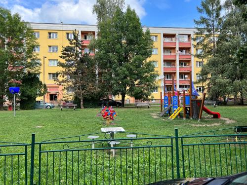 a park with a playground in front of a building at Simcity I free parking 24h self check-in in Banská Bystrica