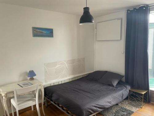 a bedroom with a bed and a table and a desk at Studio tout confort bien situé in Orléans