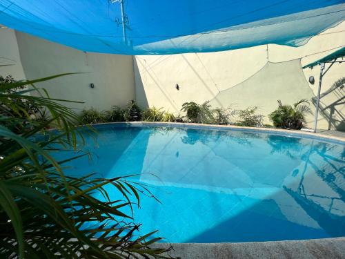 a large blue swimming pool with a blue umbrella at Condotel Room to Stay Lodging in Manila