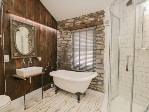 La salle de bains est pourvue d'une grande baignoire et d'un lavabo. dans l'établissement Cobble Cottage, à Kendal