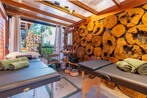 a room with two benches and a wall of logs at Pousada Vila 505 in Canela