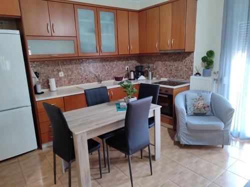 una cocina con mesa de madera y sillas y una cocina con en Όμορφο διαμέρισμα σε μονοκατοικία στη Λεπτοκαρυα., en Leptokarya