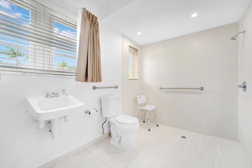 a white bathroom with a toilet and a sink at Travelodge by Wyndham Miami Biscayne Bay in Miami