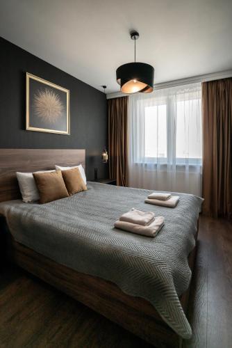 a bedroom with a large bed with two towels on it at Noche Apartamenty Premium in Biała Podlaska