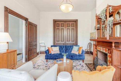 a living room with a blue couch and a fireplace at Charming Victorian Oasis with an Elegant and Spacious Haven in San Francisco