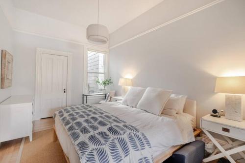 Un dormitorio blanco con una cama grande y un escritorio. en Charming Victorian Oasis with an Elegant and Spacious Haven, en San Francisco