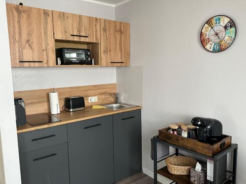 a kitchen with a sink and a clock on the wall at Vision - Apartment 43 - Bad Klosterlausnitz in Bad Klosterlausnitz