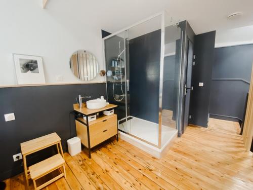 a bathroom with a shower and a wooden floor at La Maison Rose en Centre historique in Arras