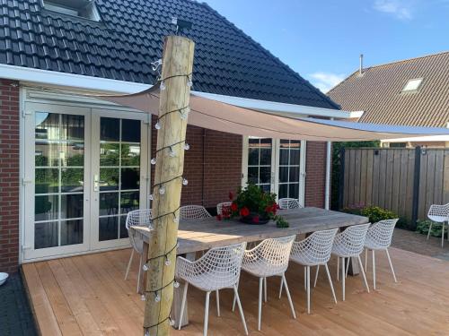 a wooden table and chairs on a patio at B&B slapen in de veenhoop in De Veenhoop