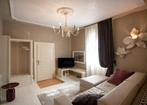 a living room with a white couch and a chandelier at La Casa di Loto Suite in Cittadella