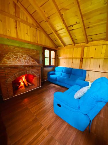 un soggiorno con divani blu e camino di Cabaña de nube a Llano Grande