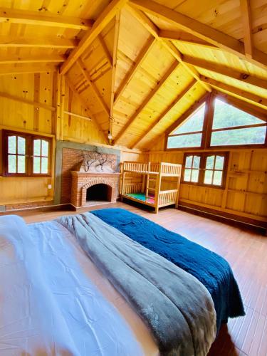 una grande camera da letto con un grande letto e un camino di Cabaña de nube a Llano Grande