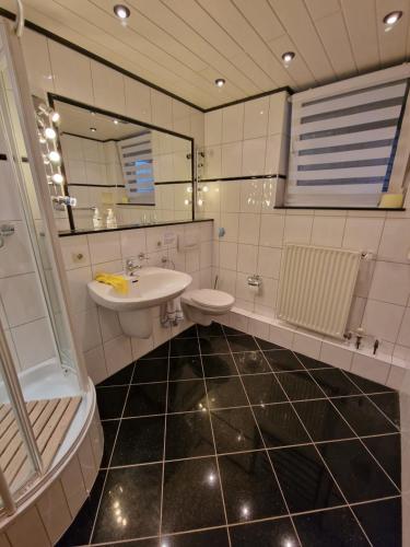 uma casa de banho com um lavatório, um WC e um espelho. em Haus der Erholung App 2 em Lotte