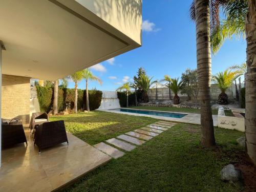 ブズニカにあるLuxury Villa Oasis, Bouznika Bayのヤシの木が茂る裏庭