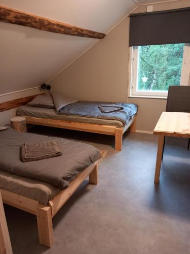 two beds in a room with a window at Sevetin Baari & Guesthouse in Sevettijärvi