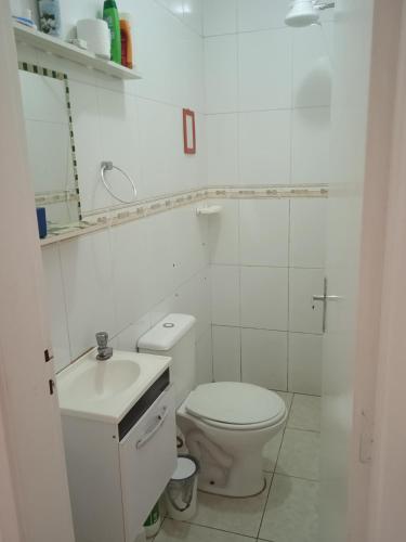a white bathroom with a toilet and a sink at Suíte com banheiro super espaçosa in São Paulo