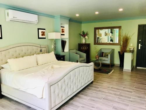um quarto com uma grande cama branca e um espelho em Boca de Tomatlán Ocean Frontage Boutique Hotel em Puerto Vallarta