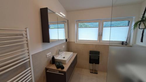 La salle de bains est pourvue d'un lavabo et d'un miroir. dans l'établissement Appartement - Penthouse Laimer, à Ebensee