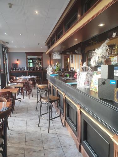 a restaurant with a bar with tables and chairs at Aux Bons Amis in Reims