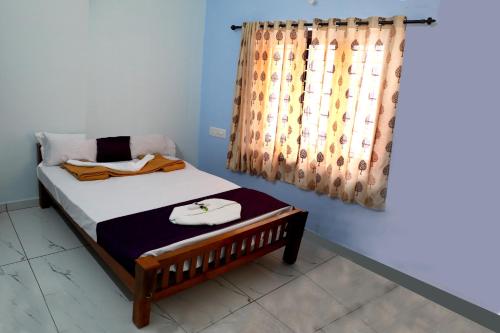 1 dormitorio con cama y cortina en DREAMS VILLA Near Rajagiri Hospital, en Alwaye