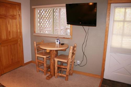 エステス・パークにあるFawn Valley Inn- 253 aptsのテレビ付きの客室で、小さなテーブルと椅子が備わります。