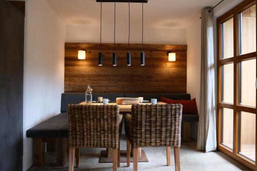 a dining room with a table and wicker chairs at Burglodge Fischerkeusche in Mauterndorf