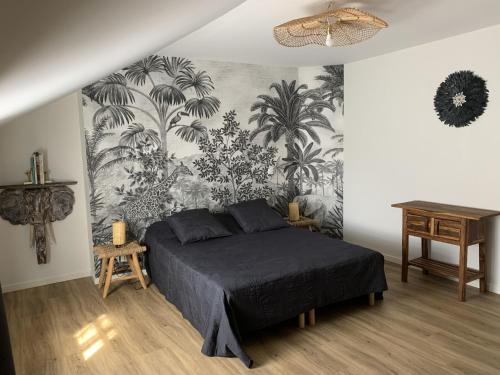 a bedroom with a bed and a wall mural at L'appartement de Purdey in Saumur
