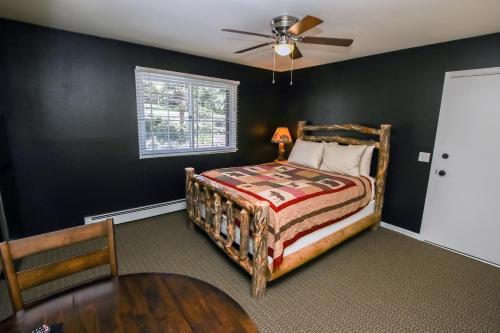 a bedroom with a bed and a table and a ceiling fan at Fawn Valley Inn- 294 condo in Estes Park