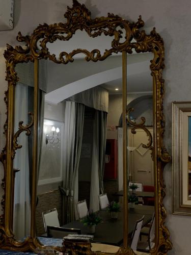 a large mirror with a gold frame on a wall at Hotel Antico Distretto in Turin