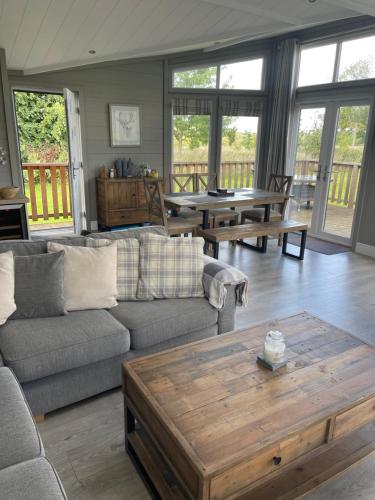 a living room with a couch and a coffee table at Glasshouse hot tub lodge in Hengrave