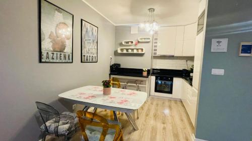 a small kitchen with a table and chairs in it at Millennium La Tour in Warsaw